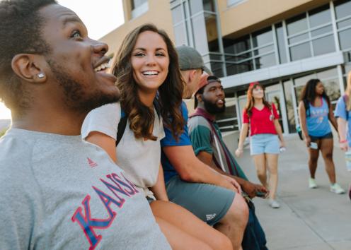 a diverse group of students outside of KU Lawrence Campus Learned Hall in a small group